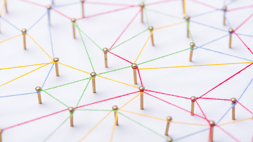 Alcuni chiodi sono collegati tra loro con fili colorati, come una rete di imprese